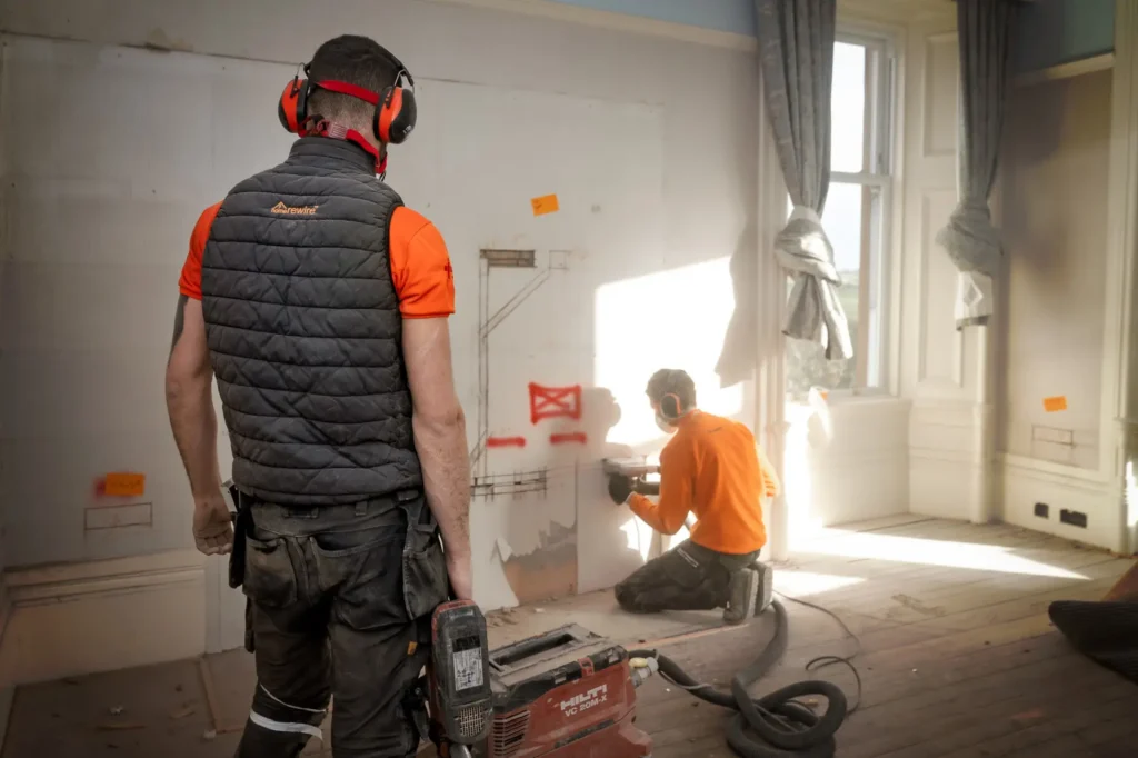 House rewire electricians cutting plastering to insert wires