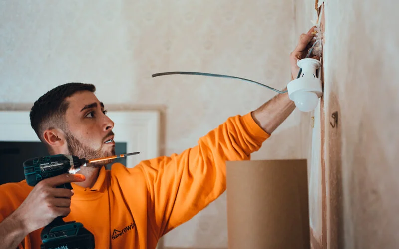 HomeRewire electrician fitting a wall light after a rewire